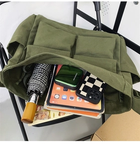 Top view of army green canvas messenger bag showing large capacity and multiple pockets