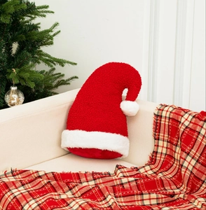 Détail du coussin de Noël en peluche rouge sur un canapé beige avec décorations