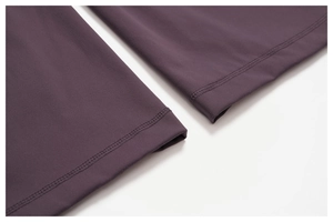 Close-up of flatlock stitching and brushed texture on dark purple yoga set fabric