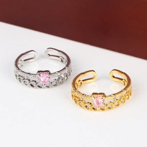 Detail of adjustable open rings in gold and silver with pink heart-shaped stones