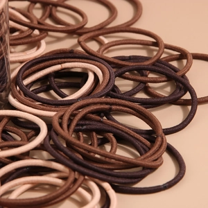 Primo piano di elastici per capelli in nylon marrone e beige in un contenitore