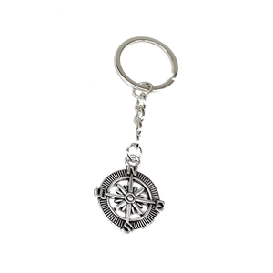 Close-up of vintage silver compass keychain with engraved N/S/E/W directional markings