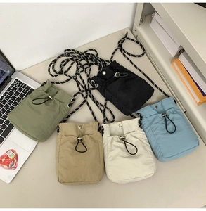 Flat lay of colorful drawstring crossbody phone bags on a desk for outdoor sports