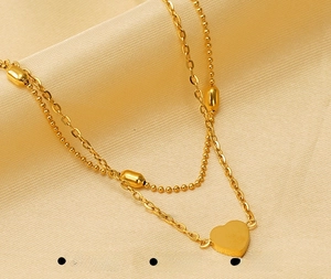 Close-up of double-layer heart anklet with polished golden finish and hollow design