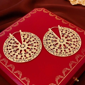 Boucles d'oreilles vintage dorées à disque ajouré avec motifs géométriques sur velours