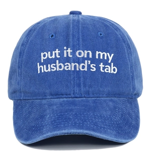 Detail of white embroidery on a blue vintage washed cotton baseball cap with text