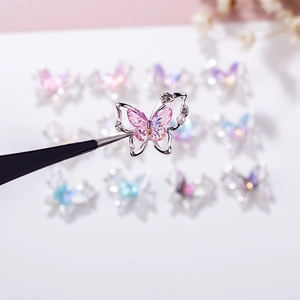 Macro view of butterfly nail charms with aurora resin wings and tiny pearl accents