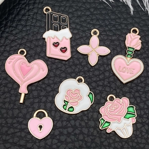 Detail of 7 pink enamel heart and floral charms on black textured leather background