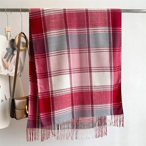 Detailed shot of red plaid scarf with fringe, styled with white blazer and leather bag