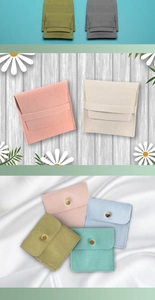 Close-up of microfiber jewelry pouches with snap buttons in various soft pastel colors