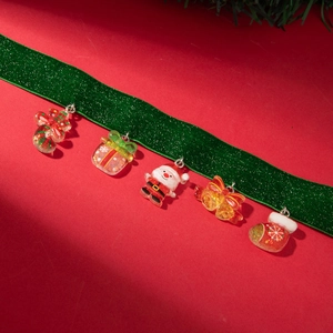 Detailed view of colorful Christmas charms with glitter on a green velvet ribbon