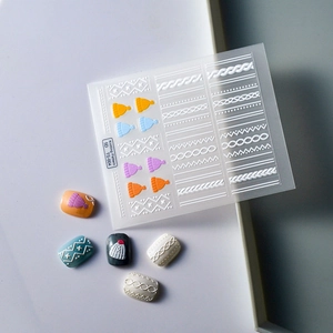 Macro view of 5D embossed nail art stickers with 3D knitting and cable patterns