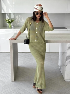 Detail of green knit two-piece set featuring hollow-out texture and buttoned cardigan