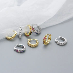 Macro shot of 925 silver hoop earrings featuring colorful zircon stones and gold finish
