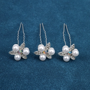 Close-up of U-shaped hair pins with pearl floral motifs and sparkling crystals