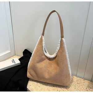 Chic brown suede tote bag with white plush trim and shoulder strap on stylish display