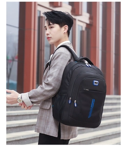Detail of a black business travel backpack with blue zippers and multiple compartments