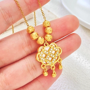 Close-up of gold Ruyi lock pendant with white crystals and small bell charms
