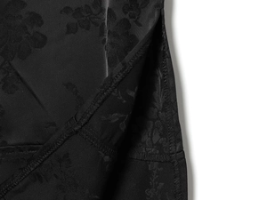 Vue détaillée du tissu jacquard floral noir et de la fente latérale sur la robe longue