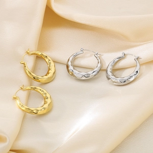 Detailed view of hammered U-shaped stainless steel earrings in gold and silver finish