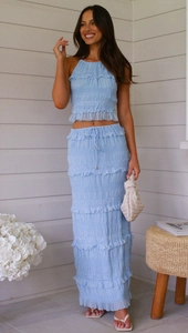 Close-up of light blue sleeveless chiffon set with pleated texture and tiered skirt