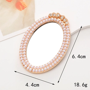 Macro view of gold vintage mini vanity mirror with pearls and rhinestones details