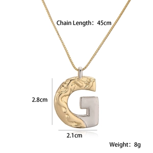 Detail view of two-tone gold and silver letter G pendant with size specs and chain length