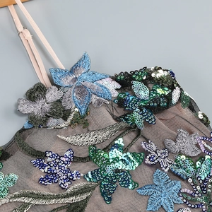 Vue détaillée de la broderie florale et des paillettes sur une robe en tulle noir