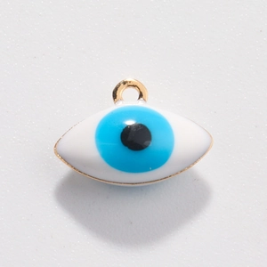 Close-up of golden evil eye charm with blue and white enamel for DIY jewelry making