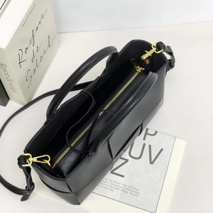 Top view of woven leather tote bag showing gold zipper detail and interior structure