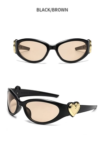 Detail view of black cat-eye sunglasses with golden heart metal buckle on temples
