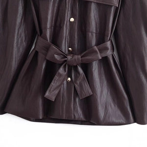 Women's long faux leather jacket in dark coffee featuring a belted waist and gold buckles