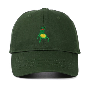 Close-up of green frog embroidery detail on a dark green cotton canvas baseball cap