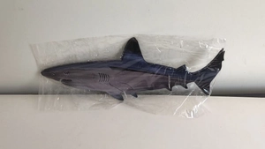 Detailed view of dark blue plastic shark toy in transparent packaging for wall decor
