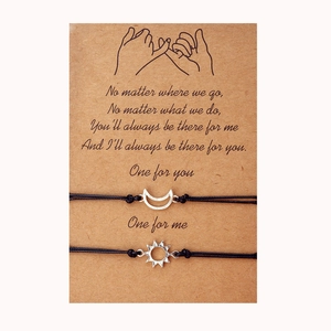 Detail view of woven sun and moon charms on friendship bracelets with message card