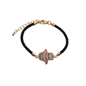 Detailed shot of black braided bracelet with golden Hamsa Hand charm and colorful crystals