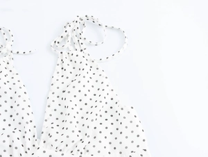 Détail du lien licou et décolleté en V profond de la robe longue blanche à pois