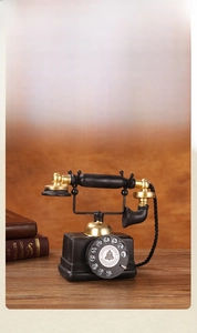 Macro shot of vintage black and gold dial telephone model with aged texture and cord