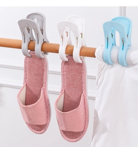 Detail of large plastic windproof clips in grey and blue securing items on a wooden rod