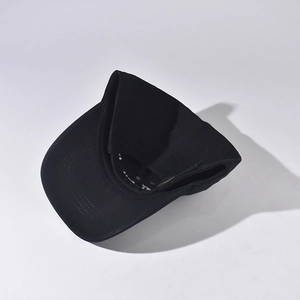 Detail of black cotton baseball cap showing adjustable metal buckle and fabric texture