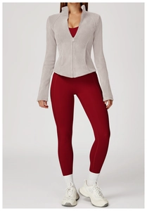 Detailed view of light gray fleece jacket styled with burgundy sportswear and white sneakers