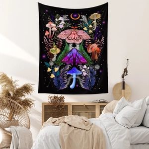 Detail of bohemian moon phase tapestry with moth and mushroom patterns on a white bedroom wall