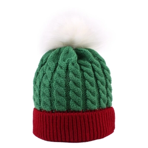 Knitted kids Christmas beanie with green cable pattern and white fluffy pom pom