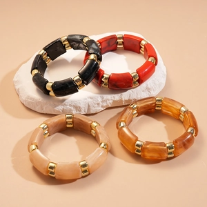 Detail of four acrylic stretch bracelets in marble patterns with gold-tone spacers