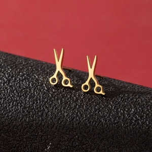 Close-up of creative golden scissor earrings with polished finish and sharp detail