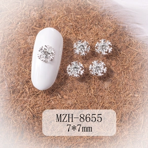 Detailed view of silver snowflake nail charms with zircon center on 7x7mm metal alloy