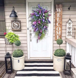 Close-up of purple lavender swag with artificial silk flowers hanging on a white door