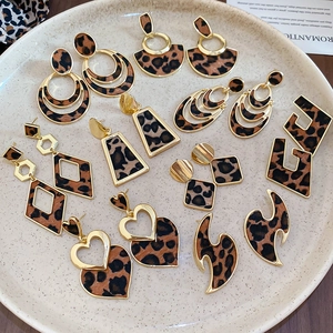Flat lay of vintage leopard print earrings in geometric shapes on a ceramic tray