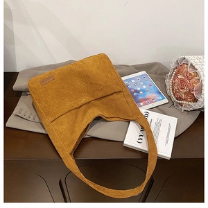 Ginger yellow corduroy tote bag styled with blazer and tablet on a wooden surface