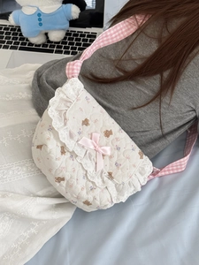 Détail du sac bandoulière matelassé avec imprimé ours, dentelle et nœud en satin